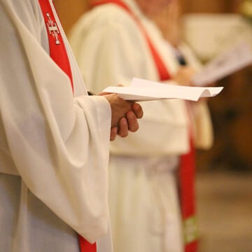 priest with hands joined in prayer during Holy Mass in church America’s Catholic Bishops Fan the Flames of Violence Against ICE