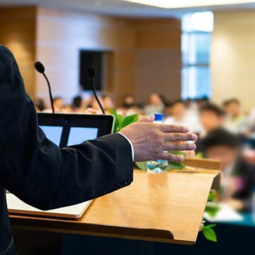Business man making a speech in front of big audience The Sage on the Stage vs. the Student-Directed Classroom