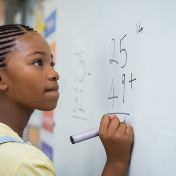 Girl solving mathematical addition Woke Math Doesn’t Add Up
