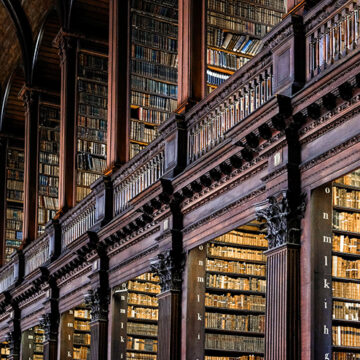 Low angle view of books on shelves in Long Room of Trinity College Old Library in Dublin. The Decline in Reading Is a Symptom of Disappearing Reality