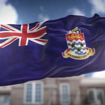 Cayman Islands Flag 3D Rendering on Blue Sky Building Background How the Cayman Islands Are Propping Up U.S. Debt