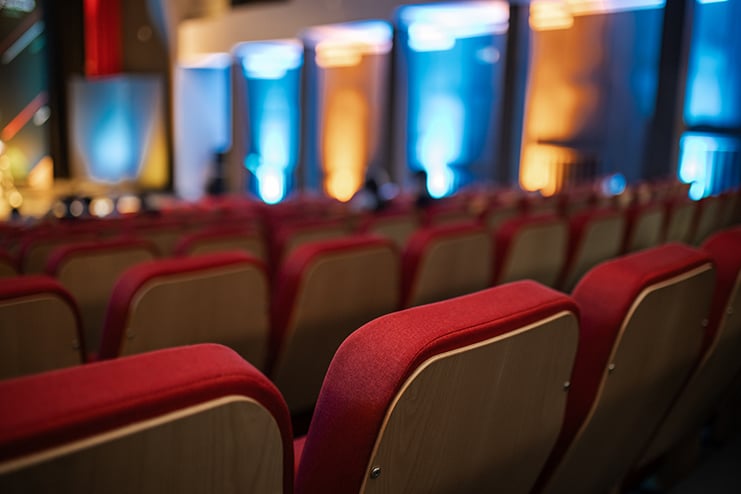 Auditorium seating with vibrant lighting and anticipation before an event in a modern venue Spoiler: Movie Critic Devoured by Trump Derangement Syndrome