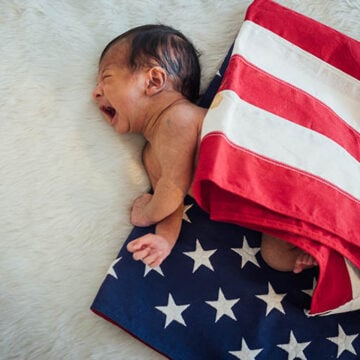 Newborn Baby on America USA flag for 4 th July USA nation day We and They