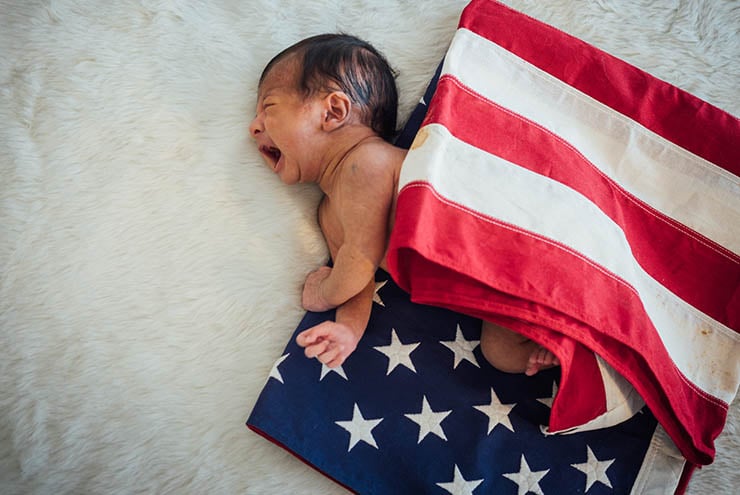 Newborn Baby on America USA flag for 4 th July USA nation day We and They